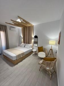 a hotel room with a bed and a chair at Akroyiali Resort in Vasiliki