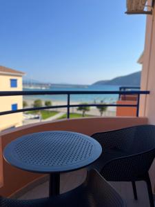 a table and chairs on a balcony with a view of the ocean at Akroyiali Resort in Vasiliki