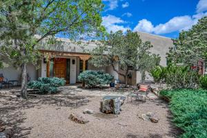 een huis met een tuin met stoelen en bomen bij Casa Tres Hermanos in Santa Fe