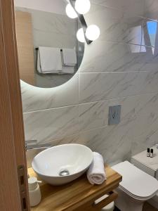 uma casa de banho com um lavatório branco e um espelho. em Akroyiali Resort em Vasiliki