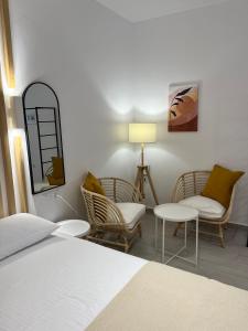 a bedroom with a bed and chairs and a lamp at Akroyiali Resort in Vasiliki