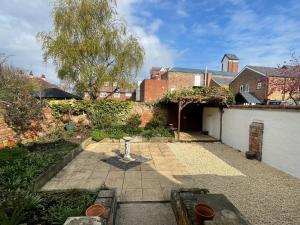 a garden with a brick building and a courtyard at Cleethorpes - New 2 Bedroom house close to beach in Cleethorpes