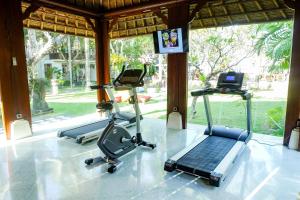 a gym with three exercise bikes and a laptop at Griya Santrian a Beach Resort in Sanur