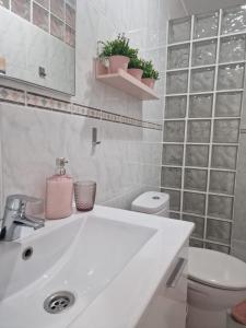 bagno bianco con lavandino e servizi igienici di Mareverde Resort- Costa adeje Tenerife ad Adeje