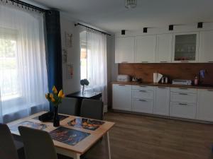 a kitchen with white cabinets and a table with flowers on it at Under the Hill 2 in Bad Muskau