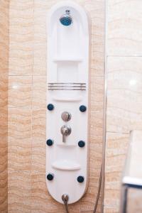 a white remote control on a wall in a bathroom at Kerama Silent Lodge in Arusha