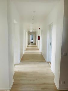 a long hallway with white walls and wooden floors at Endla Hostel ja Apartamendid in Haapsalu