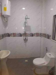 y baño con aseo blanco y lavamanos. en Comfy & cozy 2 bedroom apartment, entire unit!, en Banjul