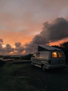 uma caravana estacionada em frente ao pôr-do-sol em Oahu Camper Adventures em Kailua