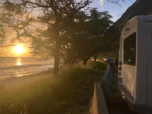 un camping-car garé sur une route à côté de l'océan dans l'établissement Oahu Camper Adventures, à Kailua