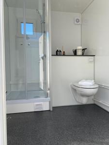 ein weißes Badezimmer mit Dusche und Toilette in der Unterkunft Green Glamping in Sønderborg + 32 Fotos