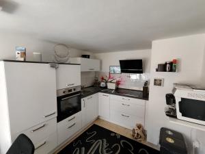 a kitchen with white cabinets and a stove top oven at Ferienhaus Bergrath in Zell an der Mosel