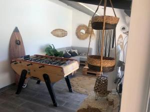 a living room with a pool table and a surfboard at Le Soustet in Malaucène