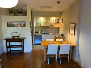 a kitchen with a table and chairs in a room at Apartament Bryza - Szczęśliwa Dziewiątka in Jurata