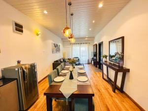 The Edge Luxury Apartment في نوارا إليا: غرفة معيشة مع طاولة طويلة عليها لوحات