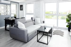 un soggiorno con divano e tavolo di Chill Apartments Jurajska Plaza Kielce Targi a Kielce
