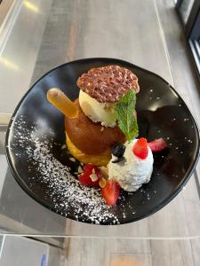 a black plate with a dessert on a table at Appartement bord de mer in Sainte-Marie-la-Mer