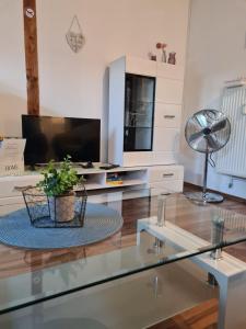 - un salon avec une télévision et une table en verre dans l'établissement Appartement Krefeld-City, à Krefeld