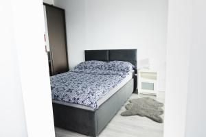 a bedroom with a bed and a rug at Chill Apartments Jurajska Plaza Kielce Targi in Kielce