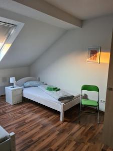 a bedroom with a bed and a green chair at Appartement Krefeld-City in Krefeld