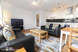 a living room with a couch and a table at Thistle Apartments - Rose Apartment in Aberdeen