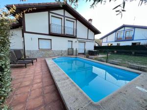 a swimming pool in front of a house at Urdaibai Boutique in Altamira