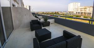 a balcony with chairs and tables on a building at Le Littoral in Berck-sur-Mer