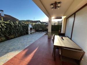 a patio with a wooden table and a fence at Urdaibai Boutique in Altamira