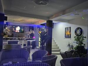 una sala de espera con sillas azules y un bar en Grand Bahia Relaxury, en Costinesti