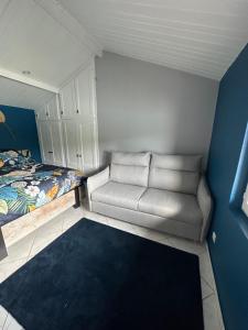 ein kleines Schlafzimmer mit einem Sofa und einem Bett in der Unterkunft Le Havre du Lac St Point in Saint-Point-Lac