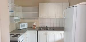 a kitchen with white cabinets and a white refrigerator at Pehtoorintupa in Ikaalinen