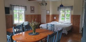 a room with a table and a bed and a bedroom at Pehtoorintupa in Ikaalinen