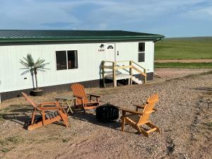 un grupo de sillas y una mesa frente a una casa en Angostura Oasis en Hot Springs