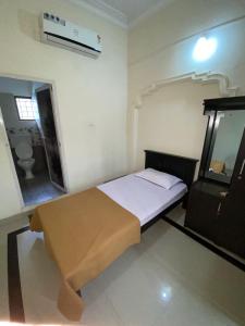 a small bedroom with a bed and a bathroom at Rosh Tower in Trivandrum
