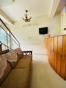 a living room with a couch and a television at Rosh Tower in Trivandrum