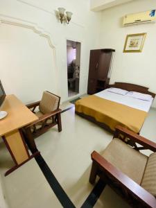 a bedroom with a bed and a desk and a chair at Rosh Tower in Trivandrum
