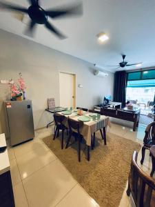 a living room with a table and chairs and a kitchen at Harmoni Homes Vista Alam in Shah Alam