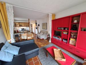 a living room with red cabinets and a couch at L'appart de Saint-Lary in Saint-Lary-Soulan