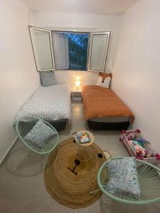 een kleine kamer met 2 bedden en een tafel bij Les Caze de la Mer Cassée in Saint-Philippe