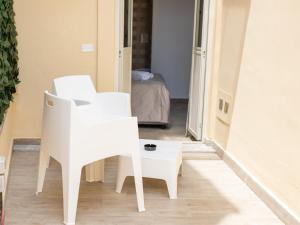 Biały fotel i stół w pokoju w obiekcie Panta Rei w mieście Lamezia Terme