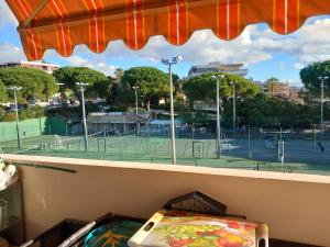 uma vista para um campo de ténis a partir de uma janela em Studio 300m plage em Saint-Laurent-du-Var