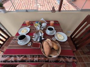 una mesa con desayuno y café. en Kuska Hostal, en Cusco