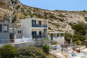 a white house with a hill in the background at Nieva Apartment 2 in Matala