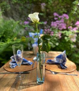 a vase with a flower in it sitting on a table at The Artist's Retreat in Calstock