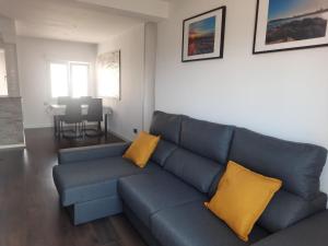 sala de estar con sofá azul y almohadas amarillas en APARTAMENTO CENTRO GIJÓN con WIFI gratis y PARKING PÚBLICO próximo incluido, en Gijón 22 fotos más
