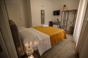 a bedroom with a bed with a yellow blanket at Panta Rei in Lamezia Terme