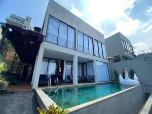 ein Haus mit einem Swimmingpool davor in der Unterkunft Double R Villa F11 Dago Village in Bengkok