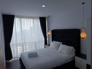 ein Schlafzimmer mit einem großen Bett mit einem großen Fenster in der Unterkunft Double R Villa F11 Dago Village in Bengkok + 56 Fotos