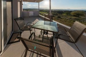 a patio with a table and chairs on a balcony at Villa P3 Paradise in Arménoi