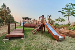 a playground with a slide and a wooden ladder at Patamma Hideaway Resort in Nan